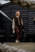 Load image into Gallery viewer, Full-length outfit featuring the Freya espresso merino wool vest, styled with neutral knitwear and brown trousers.