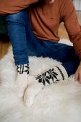 Load image into Gallery viewer, Man in woollen turtleneck and woollen knitted socks sitting on natural sheepskin rug. Men is feeling warm and cosy on winter time