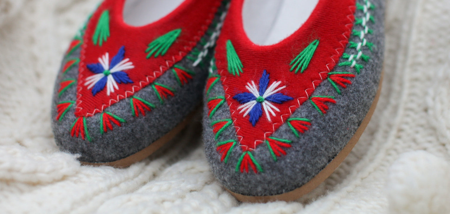 picture is showing hand embroidered felt slippers on a cosy wool jumper