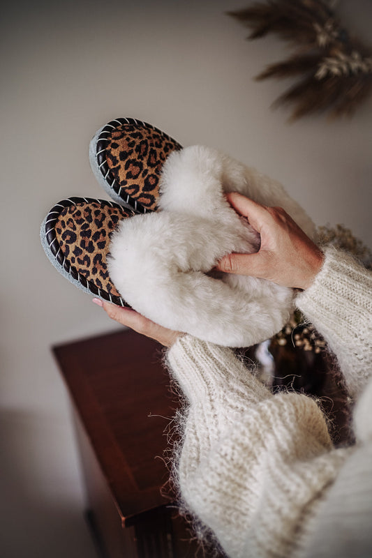 Woman with girly, ladies cute woollen fur sheepskin slippers leopard, animal pattern printed on leather