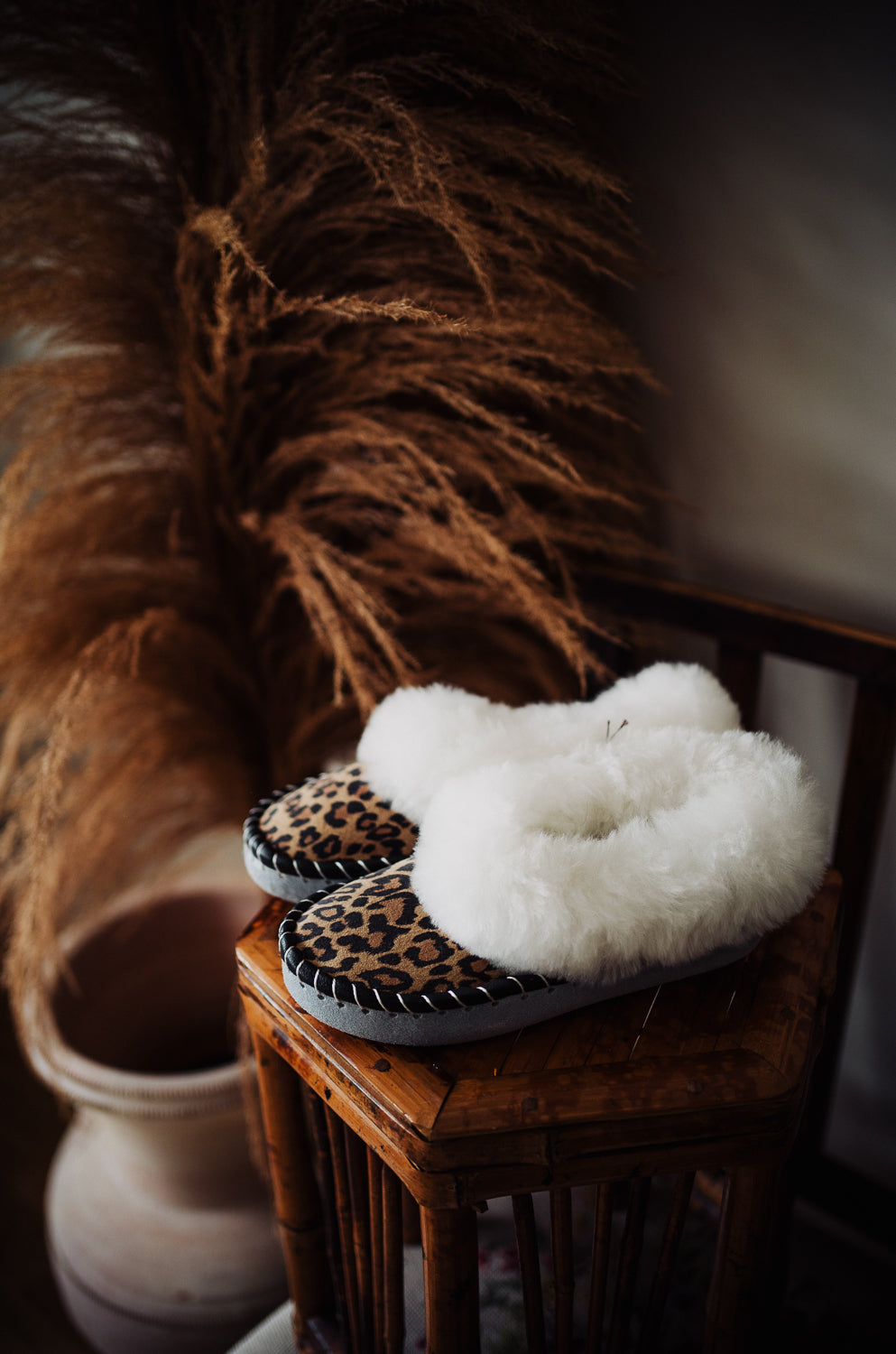 Woman with girly, ladies cute woollen fur sheepskin slippers leopard, animal pattern printed on leather