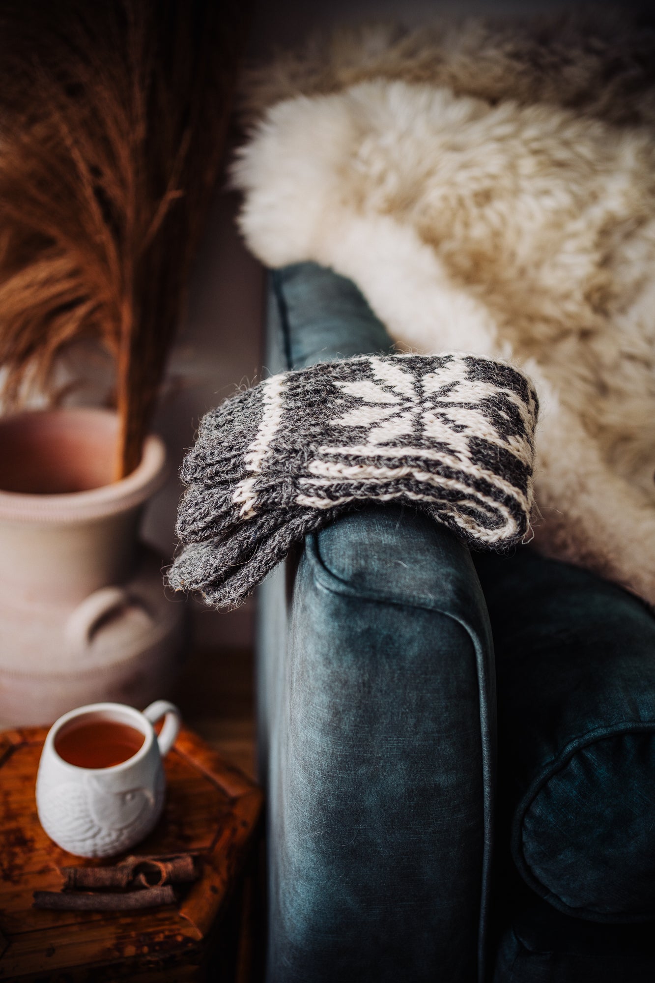 Sheepskin on the sofa , warm winter tea and woollen sock. Winter gift ideas for him