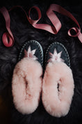 Load image into Gallery viewer,  Pink candy sheepskin slippers with a pink rim and grey leather, exquisitely hand-embroidered with pink silk thread, resting on a fluffy grey sheepskin with pink ribbon decoration.
