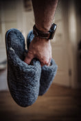Load image into Gallery viewer, Men's grey wool slippers held in a man's hand

