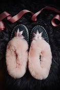 Load image into Gallery viewer, Pink candy sheepskin slippers with a pink rim and grey leather, exquisitely hand-embroidered with pink silk thread, resting on a fluffy grey sheepskin with pink ribbon decoration.
